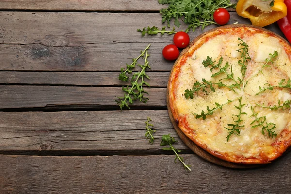Gustosa pizza decorata con erbe e verdure su sfondo di legno, primo piano — Foto Stock
