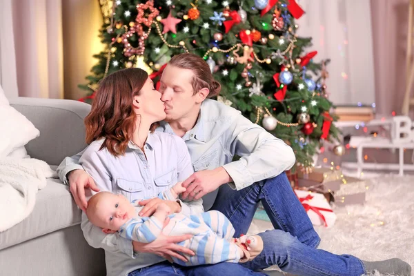 Glückliche Familie im geschmückten Weihnachtszimmer — Stockfoto