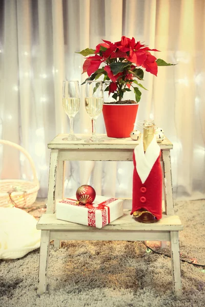 Jul blomma Julstjärna och champagne i glasen, inomhus — Stockfoto