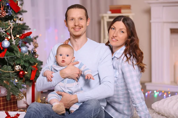 A szülők a baba közelében karácsonyfa — Stock Fotó