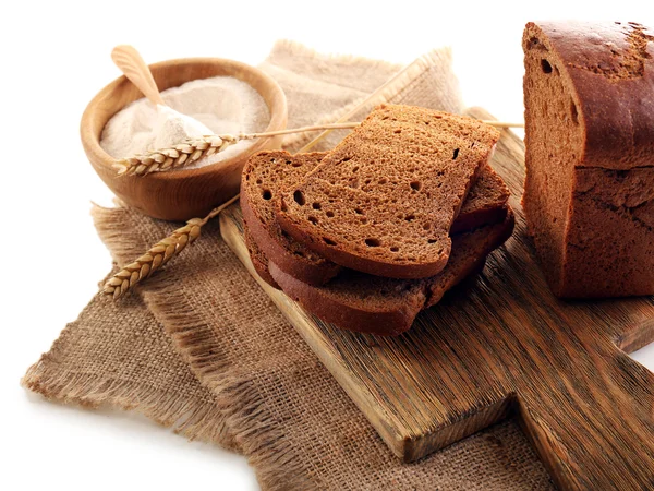 Pane affettato con spighe e farina su tovagliolo isolato su bianco — Foto Stock