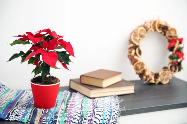 Boże Narodzenie poinsettia kwiatów i dekoracji na półce, na jasnym tle — Zdjęcie stockowe