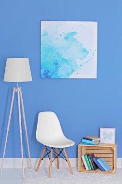 Oda tasarımı ile beyaz zemin lamba, sandalye, kitaplık ve mavi duvarın üzerinden Resim