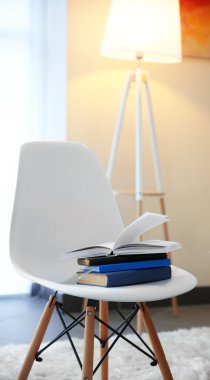 Bir odada kitaplarla beyaz sandalye