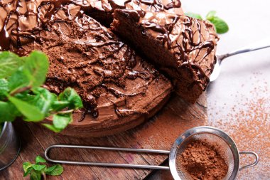 Nane ve elek ile Çikolatalı pasta kesme tahtası üzerinde dilimlenmiş