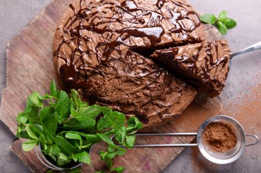 Nane ve elek yığını ile Çikolatalı pasta kesme tahtası üzerinde dilimlenmiş