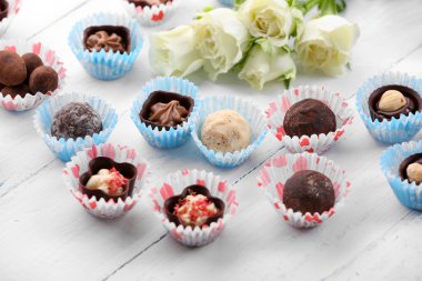 Bir ışık ahşap arka plan üzerinde çikolata şekerleme çiçekli set