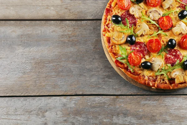 Smaczne smaczne pizza na drewnianym stole — Zdjęcie stockowe