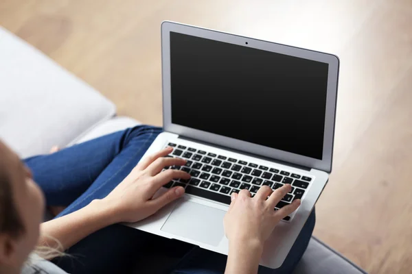 Kobieta siedząca na kanapie z laptopem — Zdjęcie stockowe
