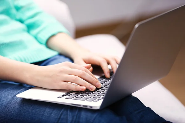 Mulher sentada no sofá com laptop — Fotografia de Stock