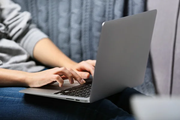 Mulher sentada no sofá com laptop — Fotografia de Stock