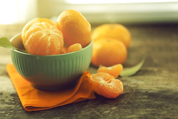 Tangerinas na tigela na velha mesa de madeira, close-up — Fotografia de Stock