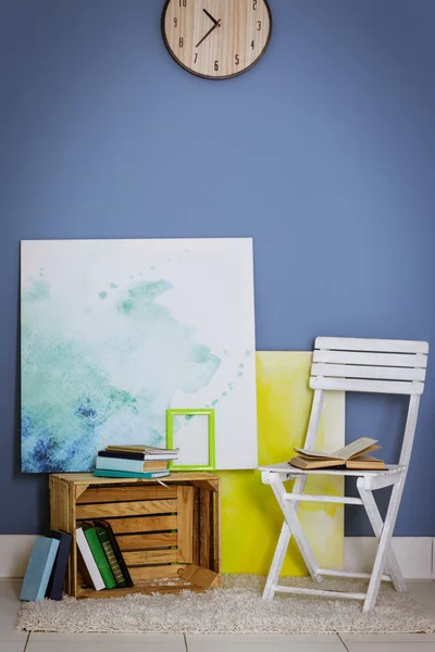 Diseño de la habitación con silla blanca, estantería, imágenes y reloj sobre pared azul — Foto de Stock