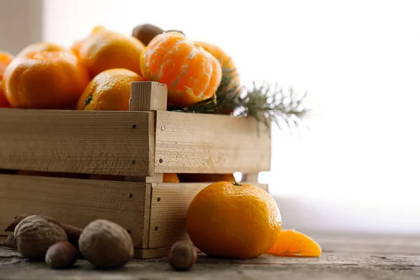 Tangerines dans une caisse en bois, sur une vieille table en bois, gros plan — Photo