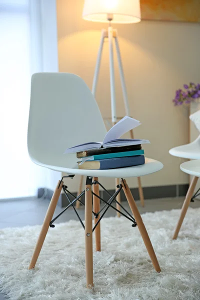 Cadeiras brancas com livros em um quarto — Fotografia de Stock