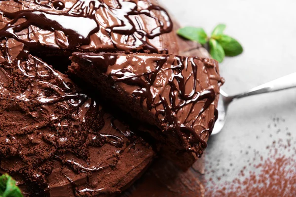 Torta de chocolate fatiada com hortelã na placa de corte — Fotografia de Stock