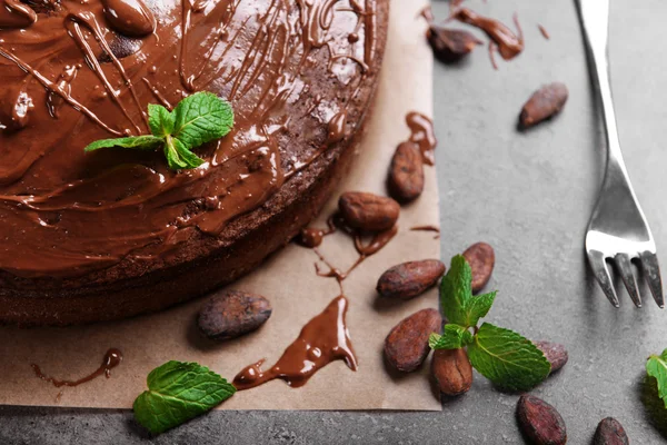 Schokoladenkuchen mit Minze, Bohnen und Gabel auf grauem Tisch — Stockfoto