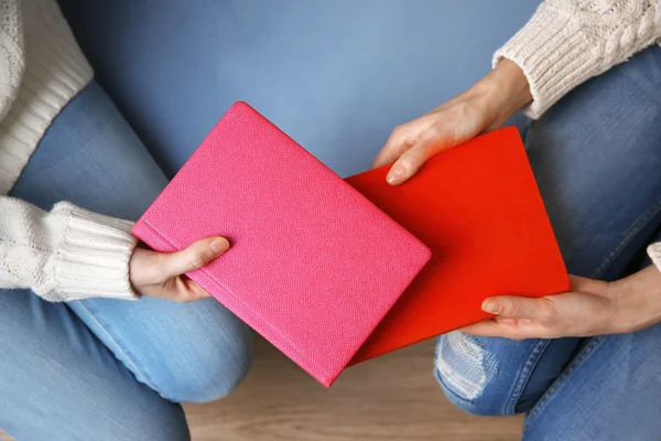 Vrouw boek geven vrouw, op houten tafel achtergrond — Stockfoto