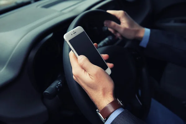 Fahrer benutzt Smartphone im Auto — Stockfoto