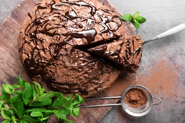 Plátky čokoládový koláč s mátou a síto na prkénku — Stock fotografie