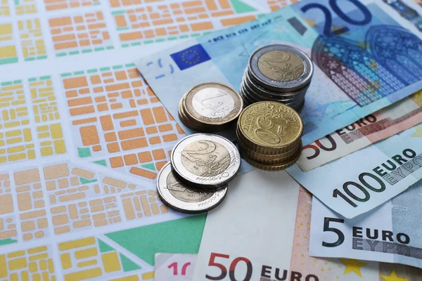 Euro-munten en bankbiljetten op kaart achtergrond — Stockfoto