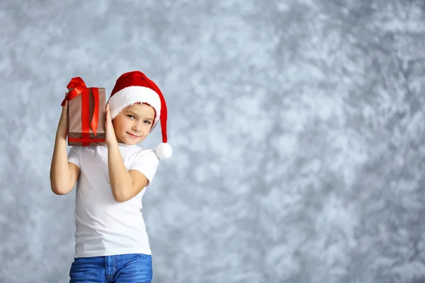 Garçon en chapeau de Père Noël avec boîte cadeau — Photo