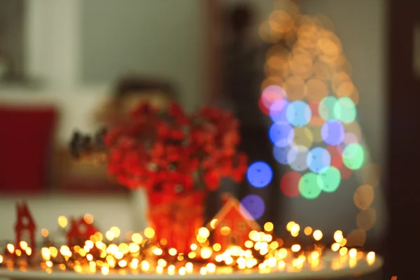 Wazig boeket van rode bessen met lichte garland op een tafel — Stockfoto