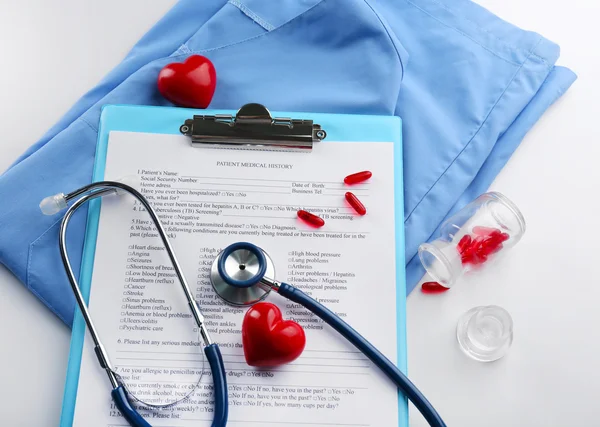 Stetoskop, kabát, plastové srdce — Stock fotografie