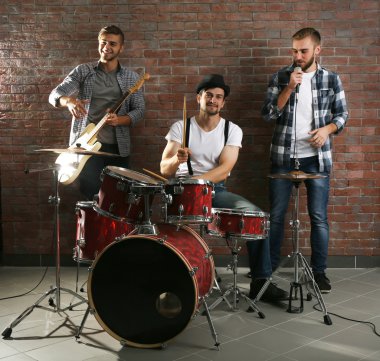 Bateri ve gitar çalmaya müzisyenler