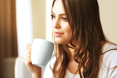 Güzel bir kadın kanepede dinleniyor.