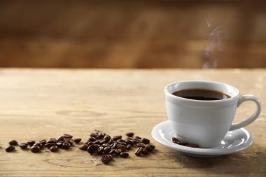 Fincan kahve ve kahve taneleri ahşap arka plan üzerinde