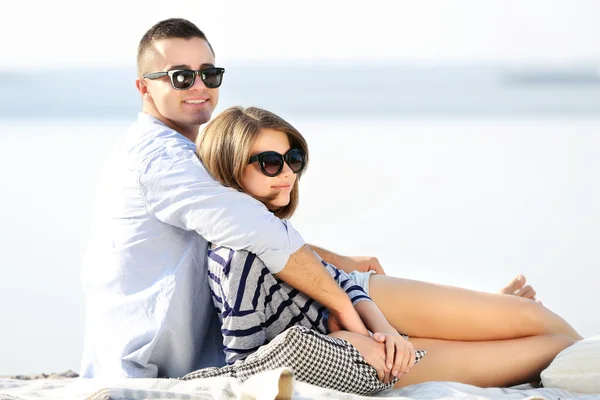 Pareja joven en la orilla del río — Foto de Stock