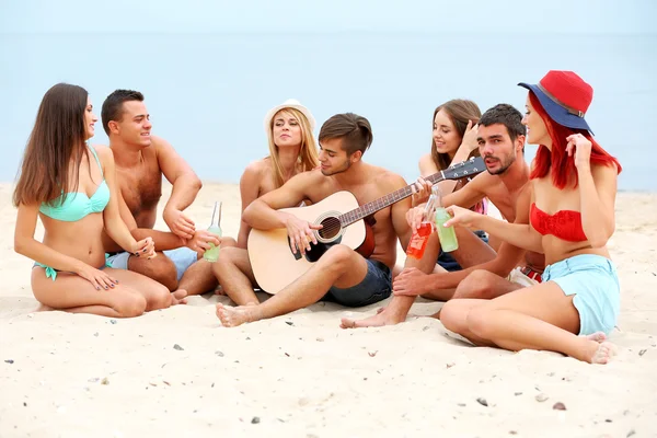 Krásných mladých lidí s kytarou na pláži — Stock fotografie