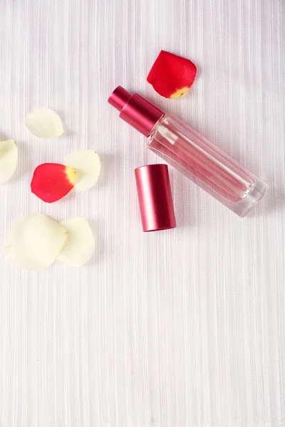 Botella de perfume y pétalos de rosa — Foto de Stock