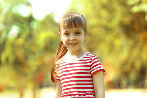 Маленькая счастливая девочка играет в парке — стоковое фото