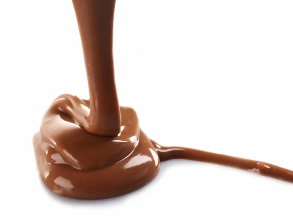 Derretido chocolate marrom leitoso derramando, isolado em branco — Fotografia de Stock