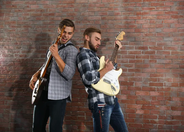 Mladí muži hrají kytary — Stock fotografie