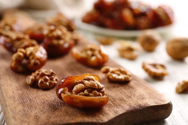 Walnut in date fruit on cutting board, close-up — Stock Photo, Image