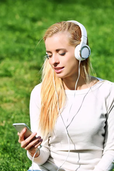 Mulher com fones de ouvido e smartphone — Fotografia de Stock