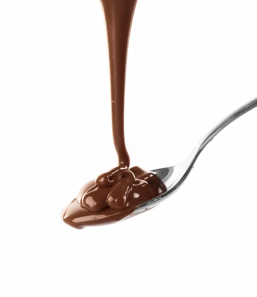 Chocolate integral leitoso derretido derramando de uma colher, isolado em branco — Fotografia de Stock