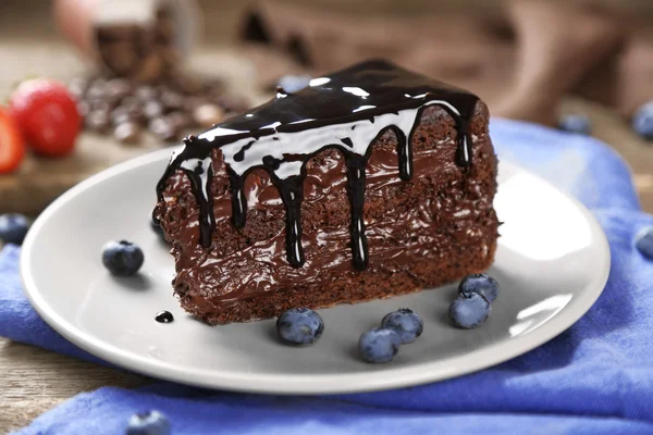 Chocolate cake met chocolade en verse bosbessen op plaat, op houten achtergrond — Stockfoto