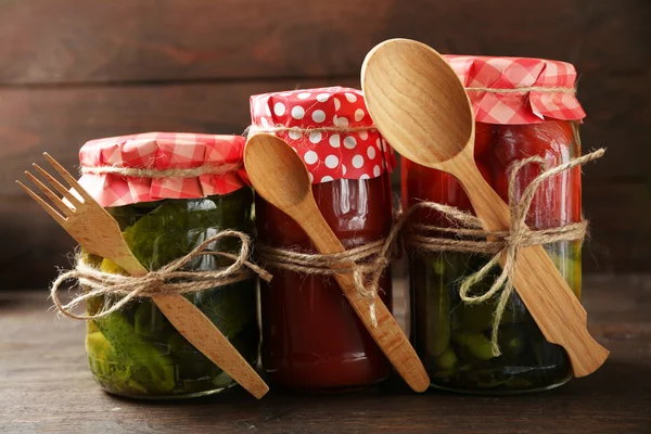 Jars with pickled vegetables on wooden background — Stock Photo, Image