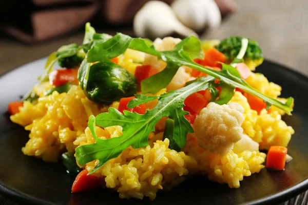 Placa preta com risoto vegetal na mesa de madeira servida — Fotografia de Stock