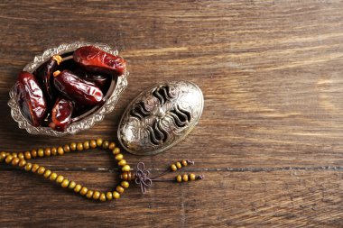 Tarihleri meyve ve tesbih ahşap arka plan üzerinde