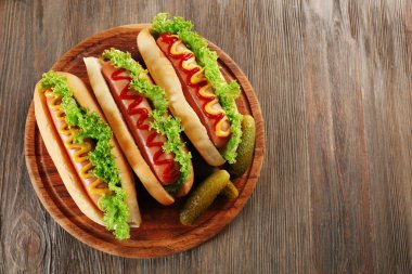 Ahşap masa üzerinde sebze ile lezzetli hot-dogs