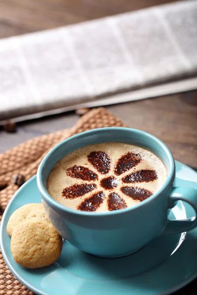 Kopje koffie en verse krant op houten tafel achtergrond — Stockfoto