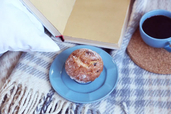 Open book, plaid and coffee on sofa. — Stock Photo, Image