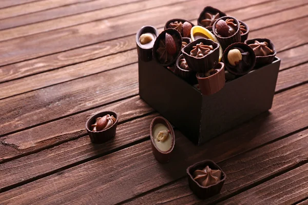 Doces de chocolate em fundo de madeira — Fotografia de Stock