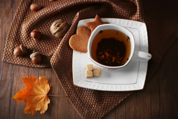 Cup of tea with autumn decor on wooden table. — Stock Photo, Image