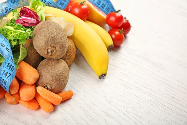Owoce, warzywa i miarkę na jasnym tle drewniane. zdrowe jedzenie koncepcja. — Zdjęcie stockowe